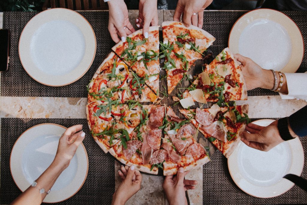 A group of friends enjoying a large pizza.